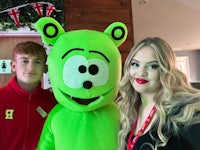 two people posing with a green mascot